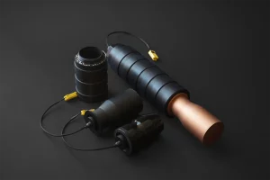 Drone warheads with modular black bodies and yellow safety plugs on dark background