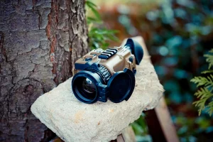 Portable thermal imaging monocular TMA put on a stone platform near a tree in natural environment
